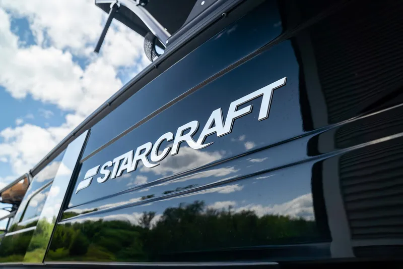 Slide: The Image of Starcraft RX 25 DL BAR 2025: Sleek design with glossy black hull and clear sky reflection. - 2