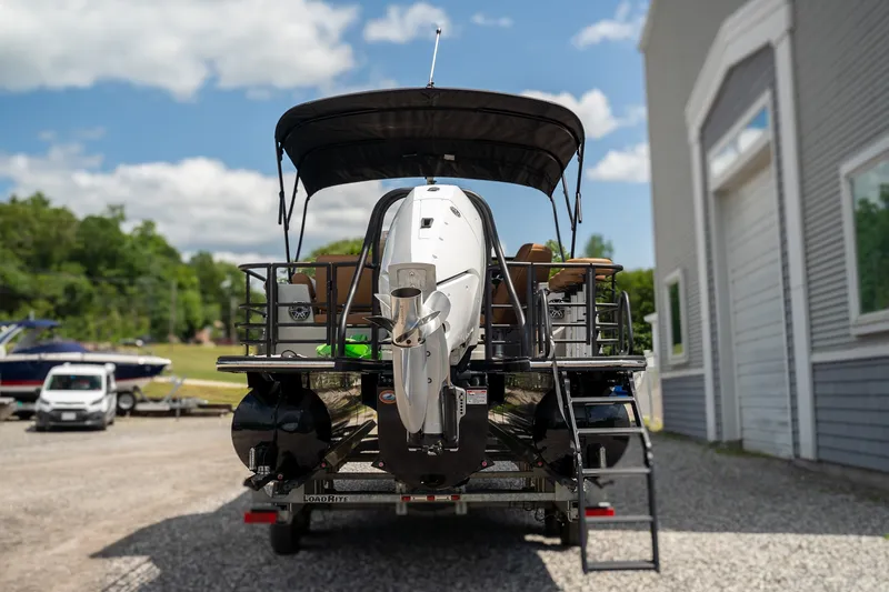 Slide: The Image of The image shows a 2025 Starcraft RX 25 DL BAR boat on a trailer next to a building. - 6