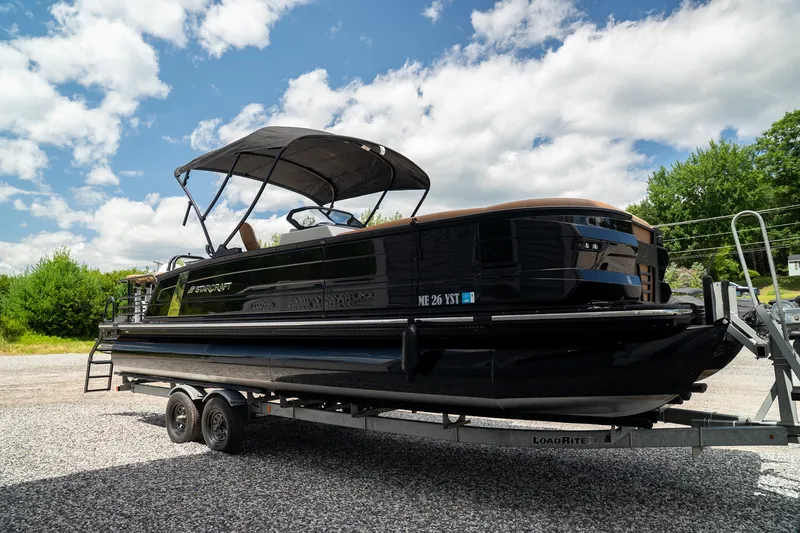Slide: The Image of Starcraft RX 25 DL BAR 2025 on a trailer, featuring a black hull and sunshade. - 4