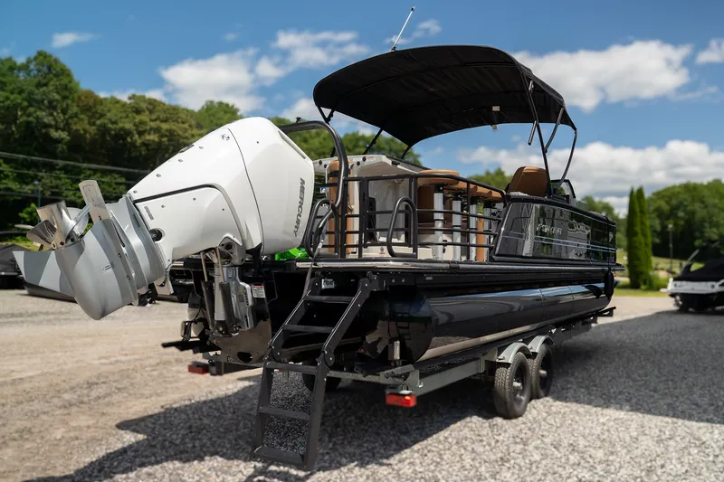 Slide: The Image of A modern pontoon boat with a black hull and large outboard motor sits on a trailer. - 5