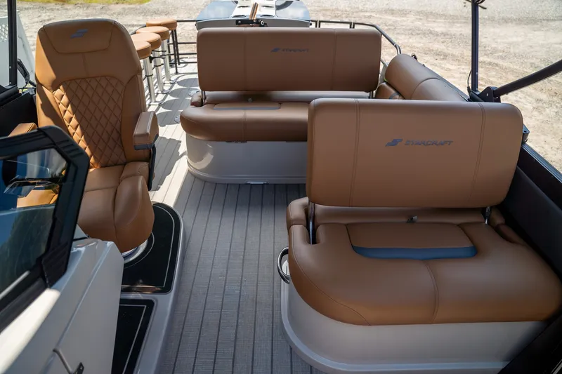 Slide: The Image of The image shows the interior of a Starcraft RX 25 DL BAR boat with brown leather seating. - 10