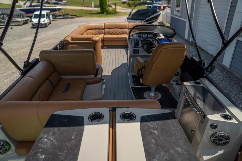 Slide: The Image of The image shows the interior of a 2025 Starcraft RX 25 DL BAR boat with luxurious seating and a modern helm. - 7
