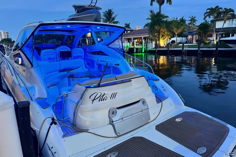 Slide: The Image of Luxurious 2009 Cranchi Mediterranee 43 yacht docked, illuminated with blue lights, surrounded by palm trees. - 23