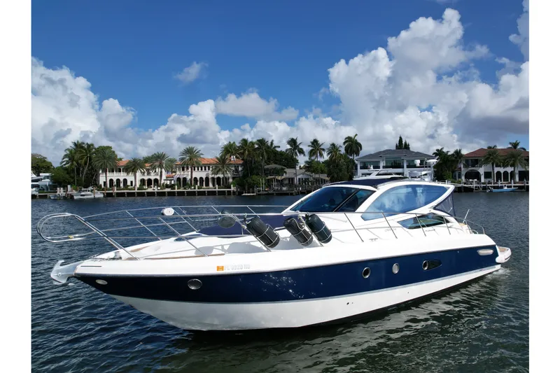 The Image of 2009 Cranchi Mediterranee 43 yacht on water, with luxury waterfront homes in the background. - 0