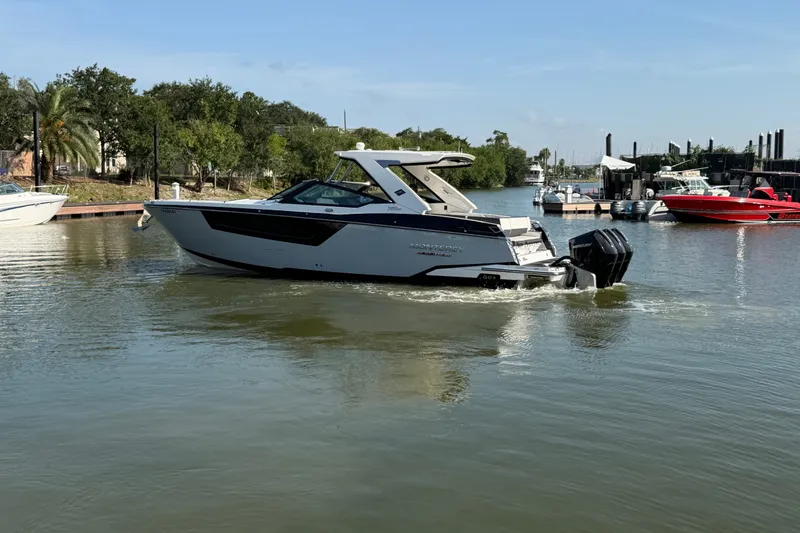 Slide: The Image of 2021 Monterey 385SE Super Express boat cruising on a calm river near a marina. - 15
