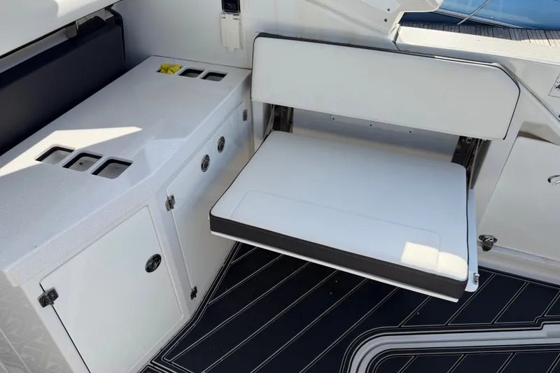 Slide: The Image of 2021 Monterey 385SE Super Express boat interior with white seating and storage compartments. - 60