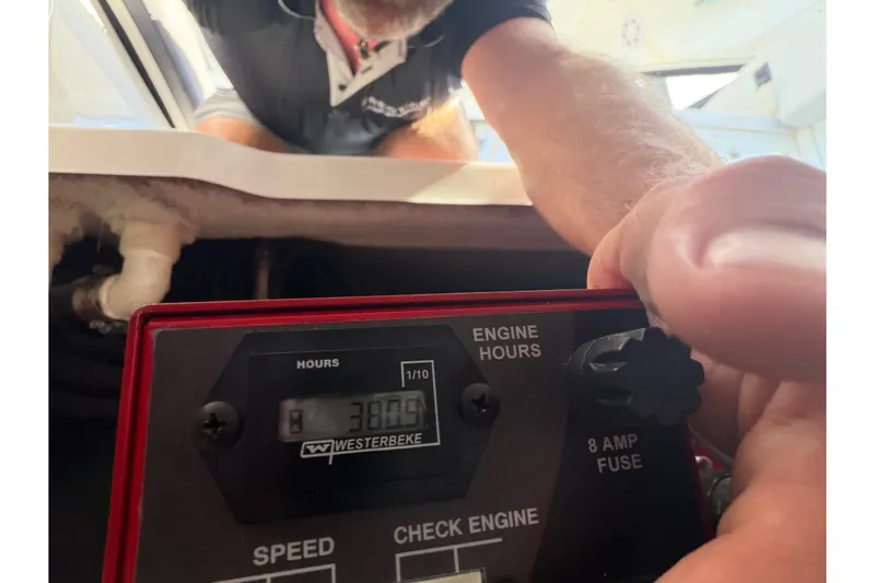 Slide: The Image of Person checking engine hours on a 2021 Monterey 385SE Super Express boat. - 56