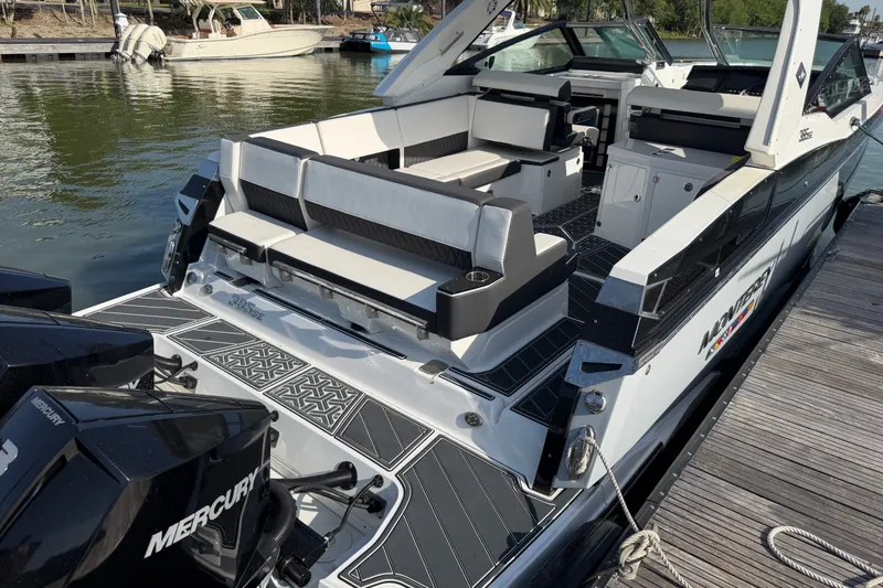 Slide: The Image of 2021 Monterey 385SE Super Express boat docked, featuring spacious seating and dual Mercury engines. - 21