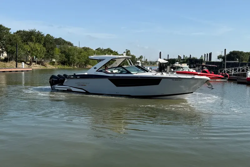 Slide: The Image of 2021 Monterey 385SE Super Express boat cruising in a calm marina setting. - 18