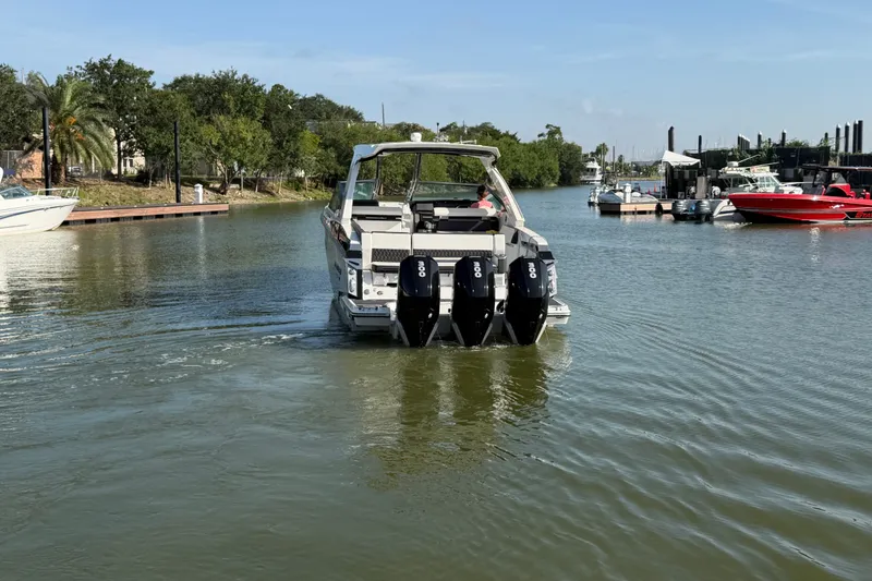 Slide: The Image of 2021 Monterey 385SE Super Express boat cruising in a scenic marina. - 14