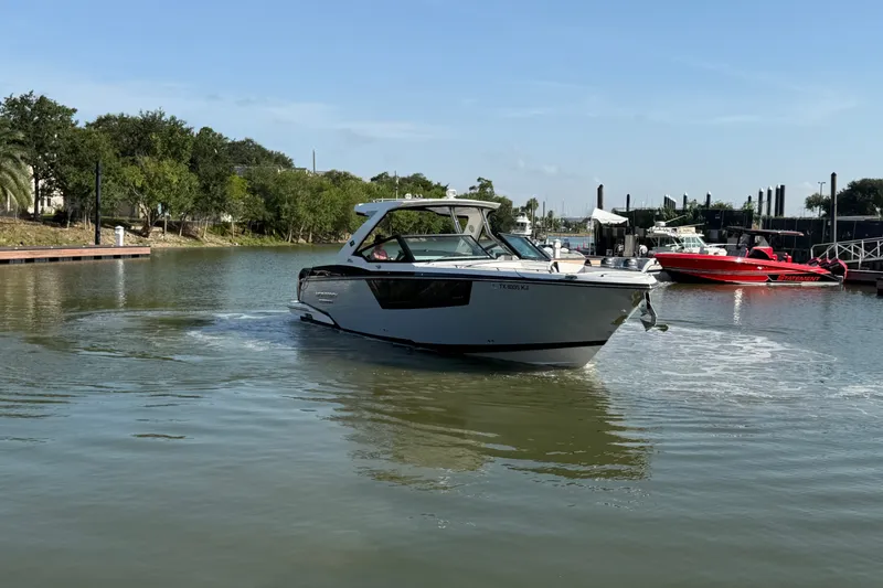 Slide: The Image of 2021 Monterey 385SE Super Express boat cruising in a calm marina setting. - 17