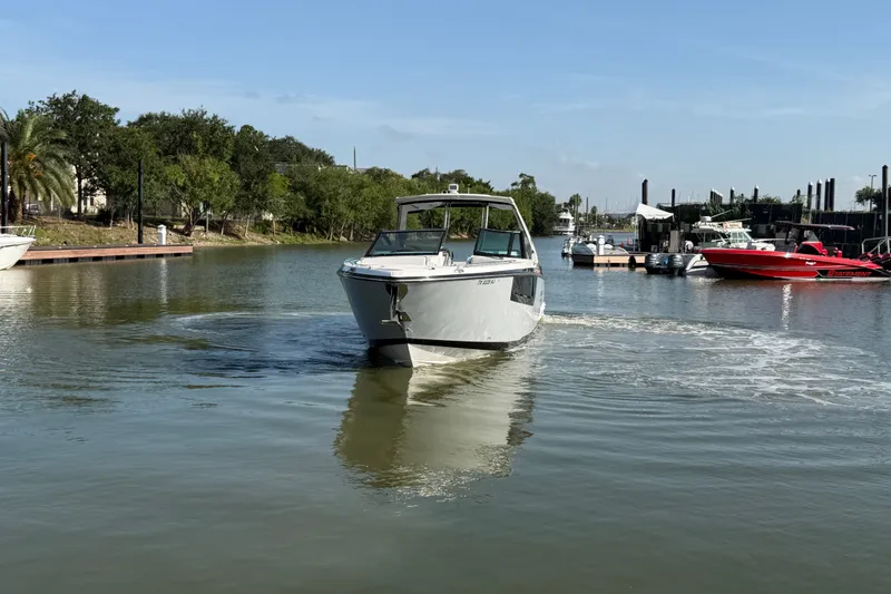 Slide: The Image of 2021 Monterey 385SE Super Express cruising in a serene marina setting. - 16