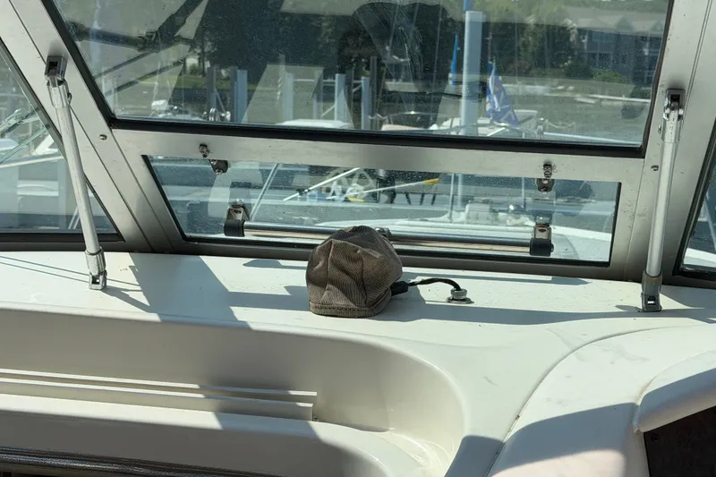 Slide: The Image of Interior view of a 1996 Sea Ray Sundancer 330 boat with a cap on the dashboard. - 15
