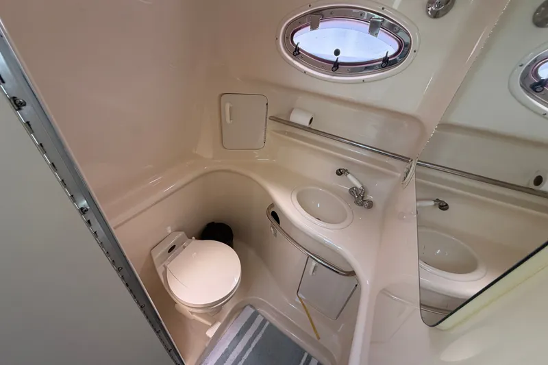 Slide: The Image of 1996 Sea Ray Sundancer 330 bathroom with toilet, sink, and porthole window. - 45