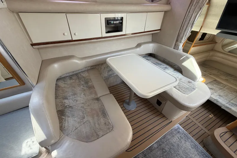 Slide: The Image of Interior of a 1996 Sea Ray Sundancer 330 with a cozy dining area and beige seating. - 28