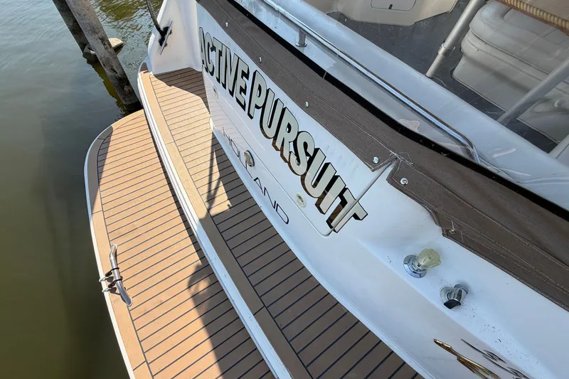 Slide: The Image of 1996 Sea Ray Sundancer 330 boat with "Active Pursuit" name, docked on water. - 6