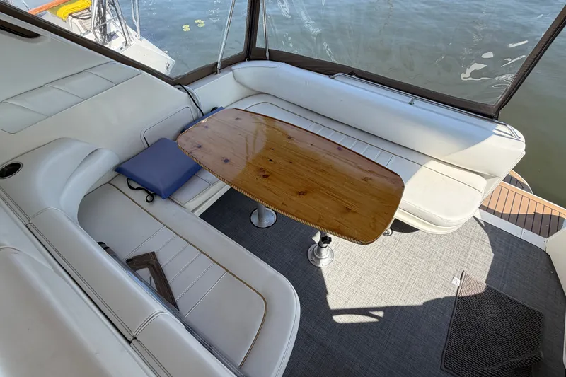 Slide: The Image of Interior of 1996 Sea Ray Sundancer 330 with white seating and wooden table. - 19