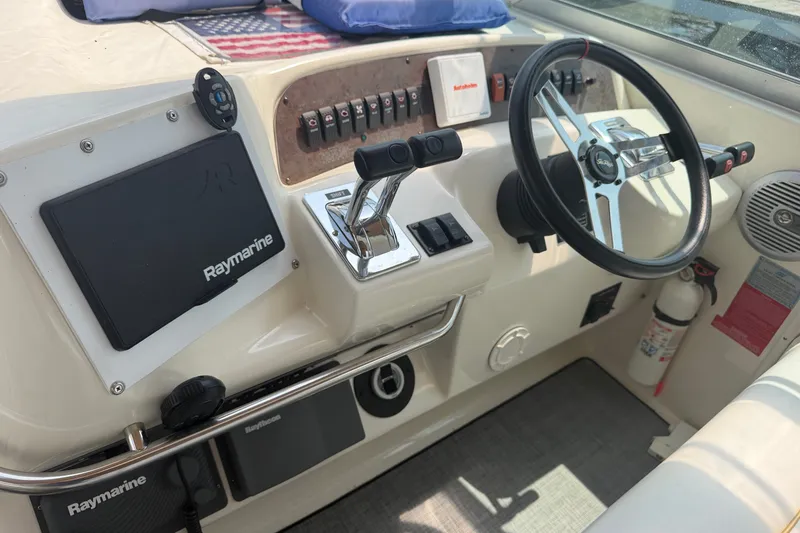 Slide: The Image of Cockpit of 1996 Sea Ray Sundancer 330 with steering wheel and Raymarine equipment. - 12