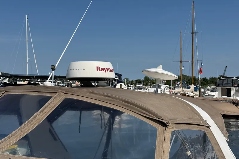 Slide: The Image of 1996 Sea Ray Sundancer 330 with Raymarine radar, docked in a marina under clear skies. - 10