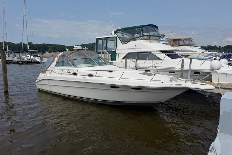 The Image of 1996 Sea Ray Sundancer 330 yacht docked at marina, surrounded by other boats. - 0