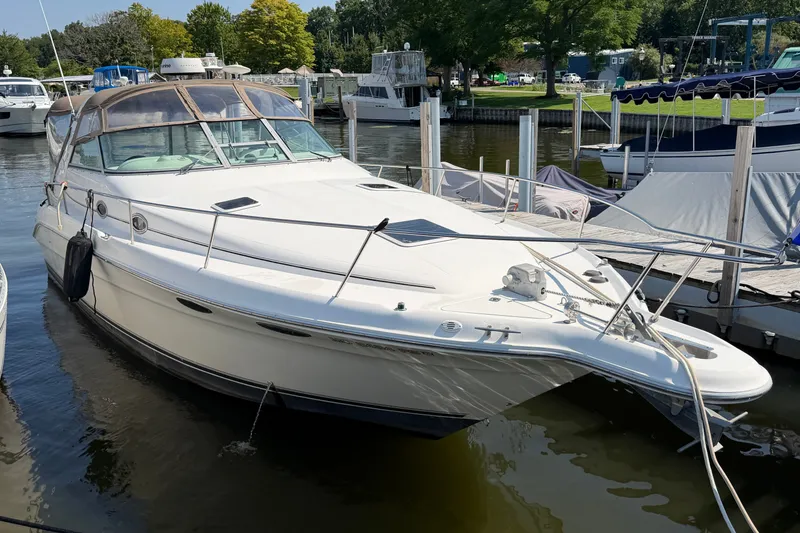Slide: The Image of 1996 Sea Ray Sundancer 330 docked at a marina, showcasing sleek design and spacious deck. - 1