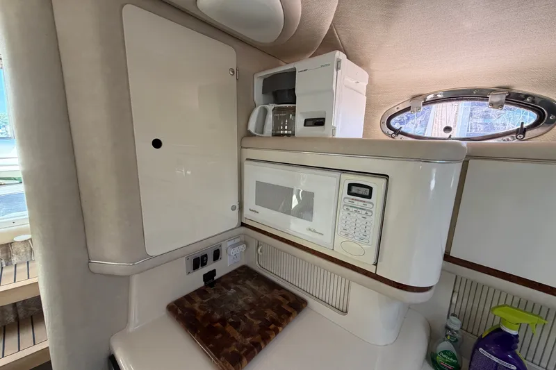 Slide: The Image of 1996 Sea Ray Sundancer 330 galley with microwave, coffee maker, and porthole window. - 31