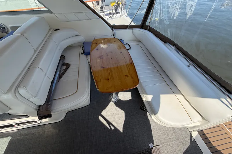 Slide: The Image of Interior of 1996 Sea Ray Sundancer 330 with white seating and wooden table. - 21