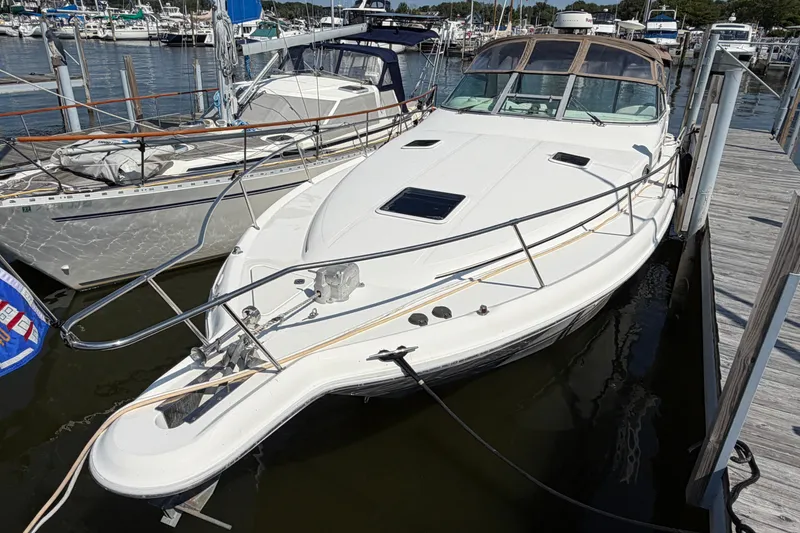 Slide: The Image of 1996 Sea Ray Sundancer 330 docked at a marina, showcasing sleek design and spacious deck. - 3