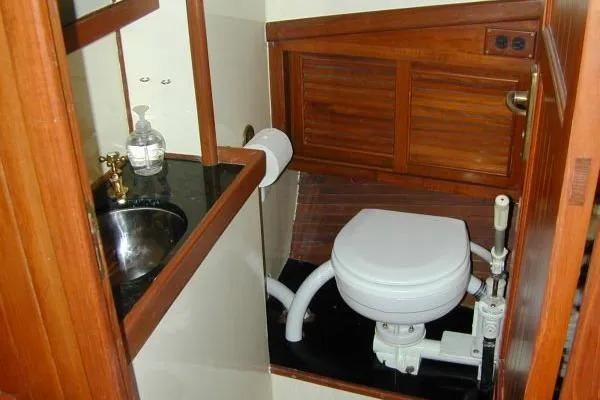Slide: The Image of 1983 Lord Nelson Victory Tug bathroom with wooden cabinetry and marine toilet. - 24