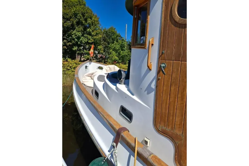 Slide: The Image of 1983 Lord Nelson Victory Tug/Trawler with wooden accents docked by lush greenery. - 27