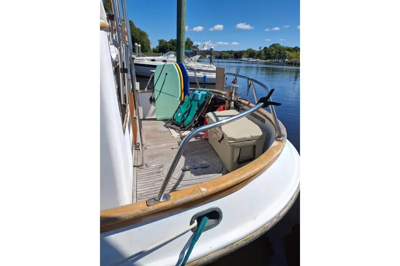 Slide: The Image of 1983 Lord Nelson Victory Tug/Trawler docked, featuring deck equipment and serene water backdrop. - 28