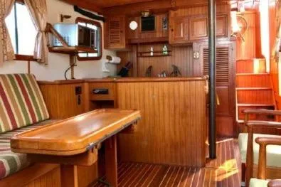 Slide: The Image of 1983 Lord Nelson Victory Tug interior with wooden furnishings and striped seating. - 34