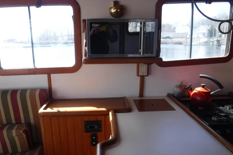Slide: The Image of Cozy 1983 Lord Nelson Victory Tug kitchen with microwave and red kettle. - 44