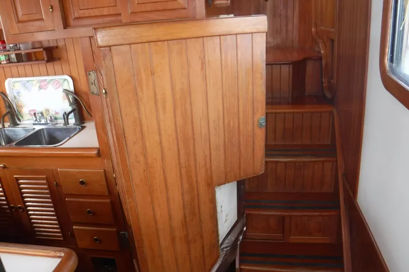 Slide: The Image of Wooden interior of 1983 Lord Nelson Victory Tug, featuring a compact kitchen and stairs. - 46