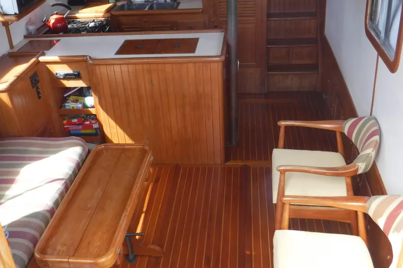 Slide: The Image of Interior of 1983 Lord Nelson Victory Tug, featuring wooden furnishings and cozy seating area. - 49