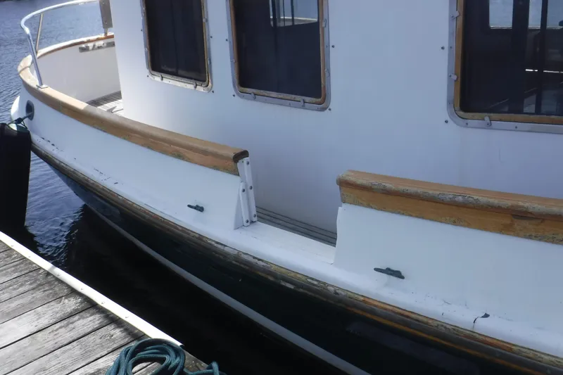 Slide: The Image of 1983 Lord Nelson Victory Tug/Trawler docked, showcasing wooden railings and windows. - 52