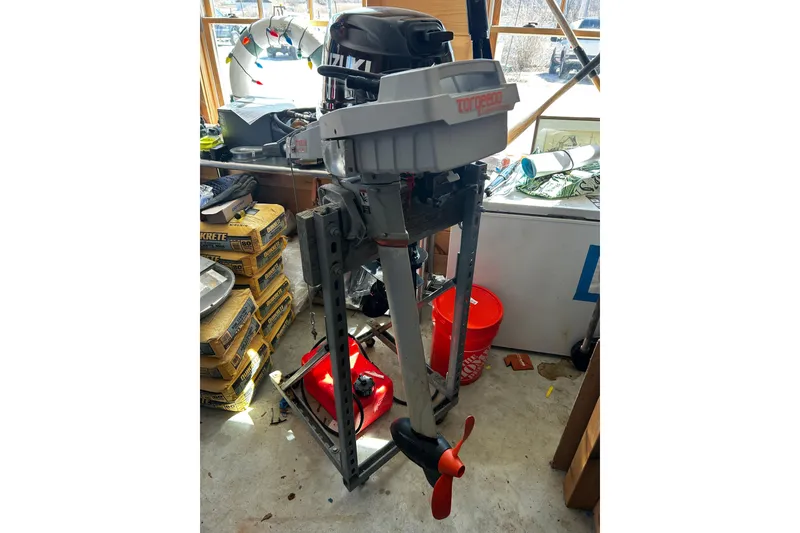 Slide: The Image of Outboard motor in a workshop, surrounded by tools and equipment. - 54