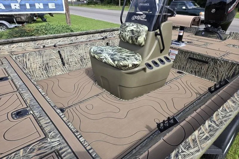 Slide: The Image of 2025 Tracker Grizzly 2072 CC boat interior with camouflage seating and textured flooring. - 10