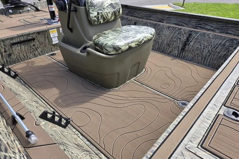 Slide: The Image of 2025 Tracker Grizzly 2072 CC boat interior with camo seats and textured flooring. - 14