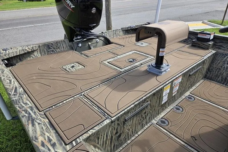 Slide: The Image of 2025 Tracker Grizzly 2072 CC boat deck with camo design and Mercury outboard motor. - 3