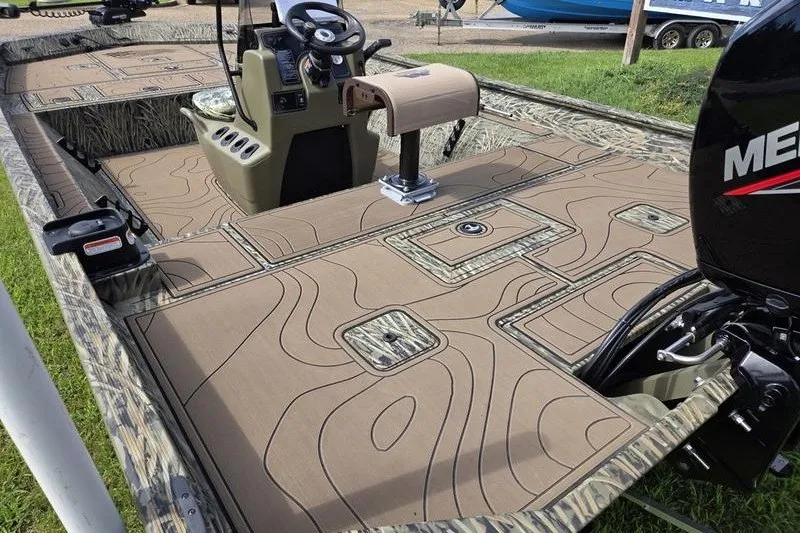 Slide: The Image of 2025 Tracker Grizzly 2072 CC boat interior with camo design and Mercury engine. - 6