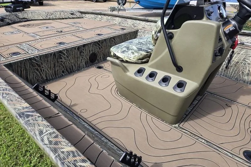 Slide: The Image of 2025 Tracker Grizzly 2072 CC boat interior with camouflage seating and textured flooring. - 12
