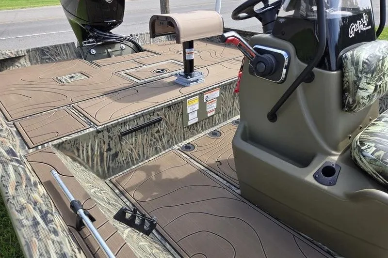 Slide: The Image of 2025 Tracker Grizzly 2072 CC boat interior with camouflage seating and control console. - 18