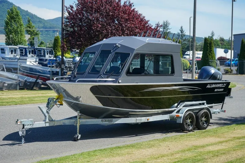 Slide: The Image of 2026 Alumaweld Intruder Outboard 22 boat on trailer, parked outdoors. - 18