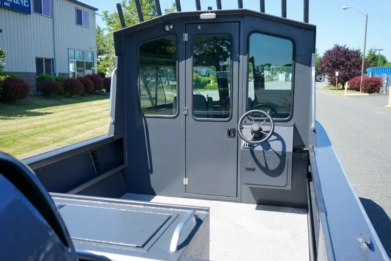Slide: The Image of 2026 Alumaweld Intruder Outboard 22 boat interior with steering wheel and cabin doors. - 6