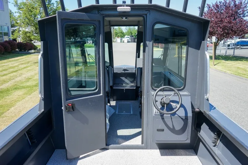 Slide: The Image of 2026 Alumaweld Intruder Outboard 22 boat interior with steering wheel and cabin view. - 11