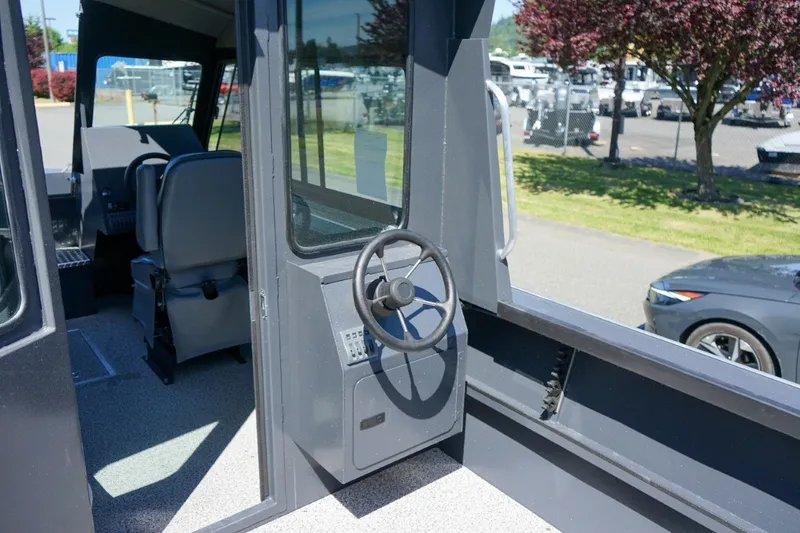Slide: The Image of Interior view of 2026 Alumaweld Intruder Outboard 22 boat, featuring steering wheel and seating. - 10