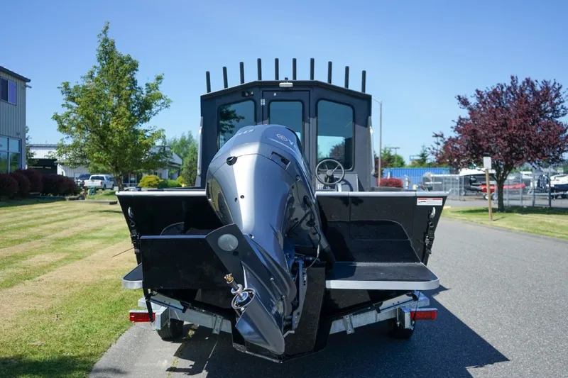 Slide: The Image of 2026 Alumaweld Intruder Outboard 22 boat with powerful engine, parked outdoors on a sunny day. - 5