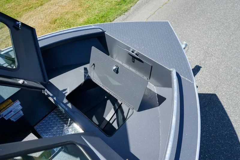 Slide: The Image of 2026 Alumaweld Intruder Outboard 22 boat storage compartment, open on a sunny day. - 17