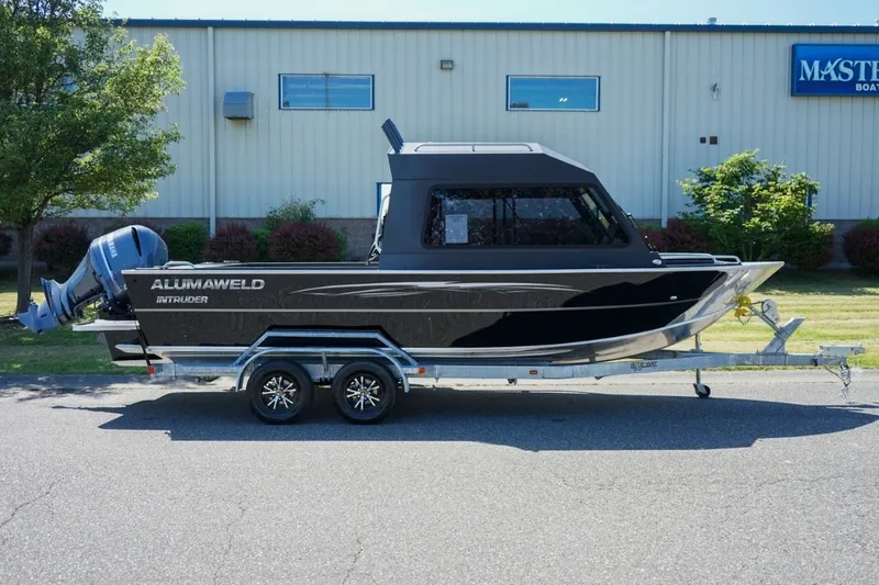 Slide: The Image of 2026 Alumaweld Intruder Outboard 22 boat on trailer, parked outdoors. - 3